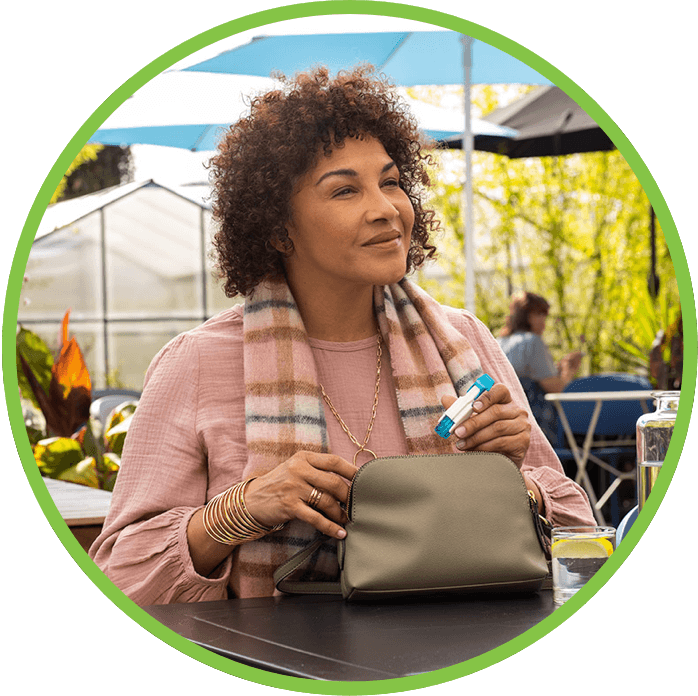 woman taking tyvaso out of purse and smiling